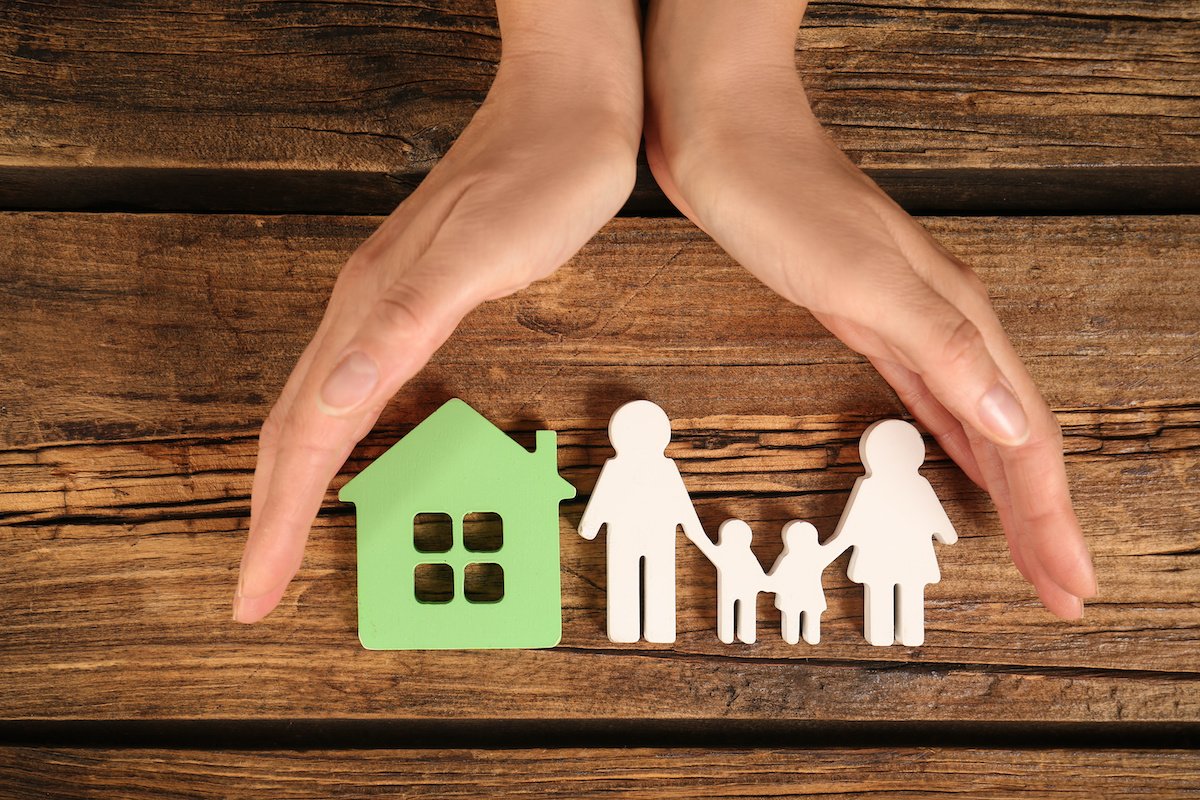 A cutout of a family of four and their property