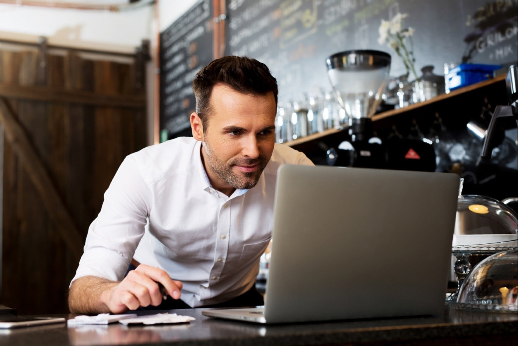 Small Business Owner on his laptop running a cafe business